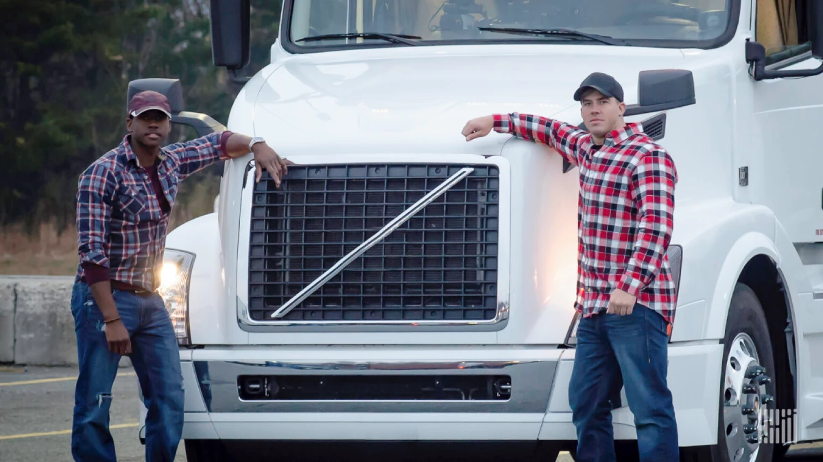 two drivers standing in front of their truck